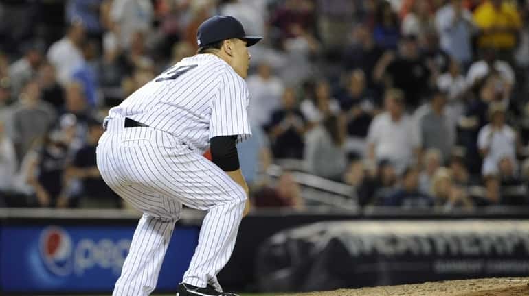 Yankees pitcher Masahiro Tanaka reacts on the mound to a...