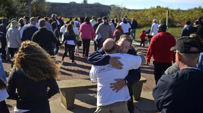 John Brower, 59, receives a hug from a friend before...
