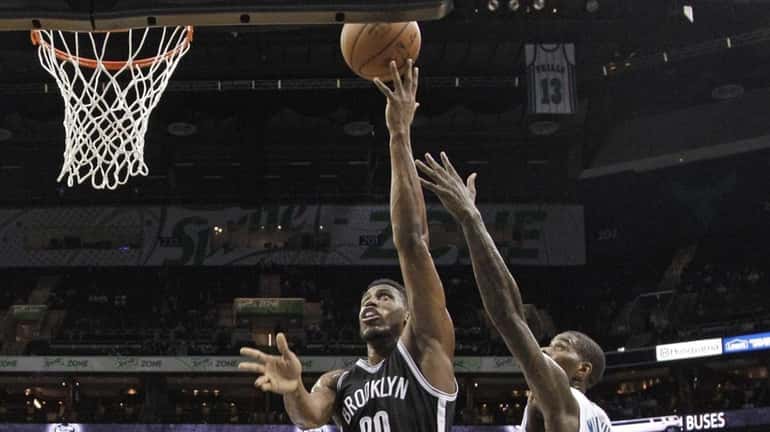 Brooklyn Nets' Thaddeus Young (30) drives between Charlotte Hornets' Marvin...
