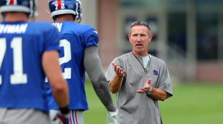 New York Giants defensive coordinator Steve Spagnuolo works with players...