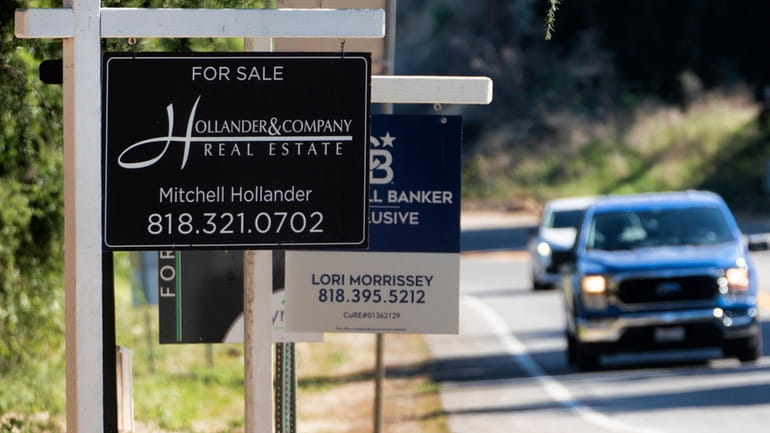 File - Home sale signs are posted along Topanga Canyon...