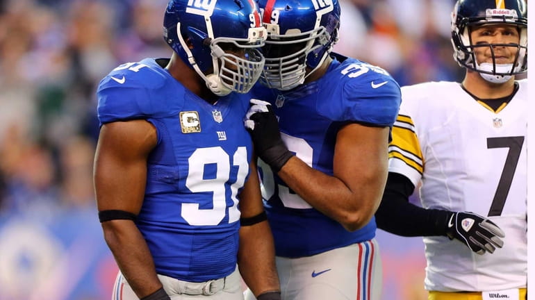 Justin Tuck celebrates his first-quarter sack with teammate Chris Canty...