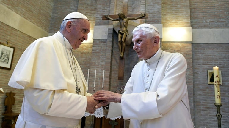 Pope Francis, left, and Pope Benedict XVI, meet each other...