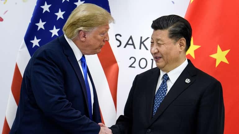 China's President Xi Jinping shakes hands with President Donald Trump...