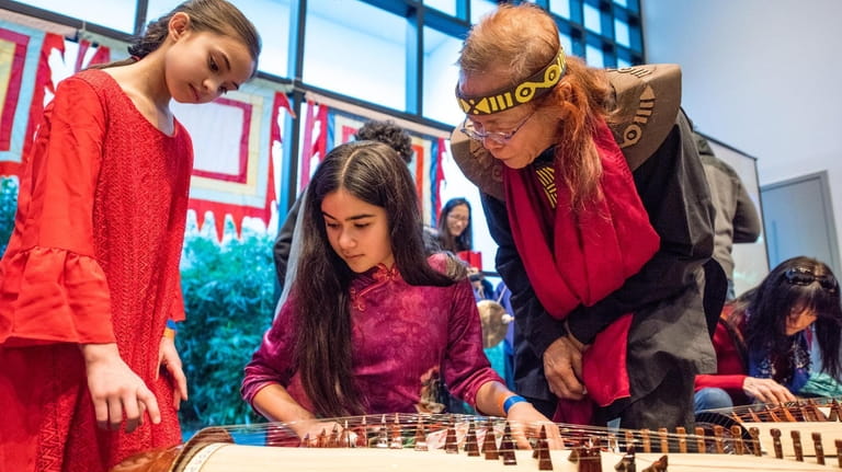 Catalina Kreeitzman, 10, left, of Smithtown, learns to play the guzheng,...