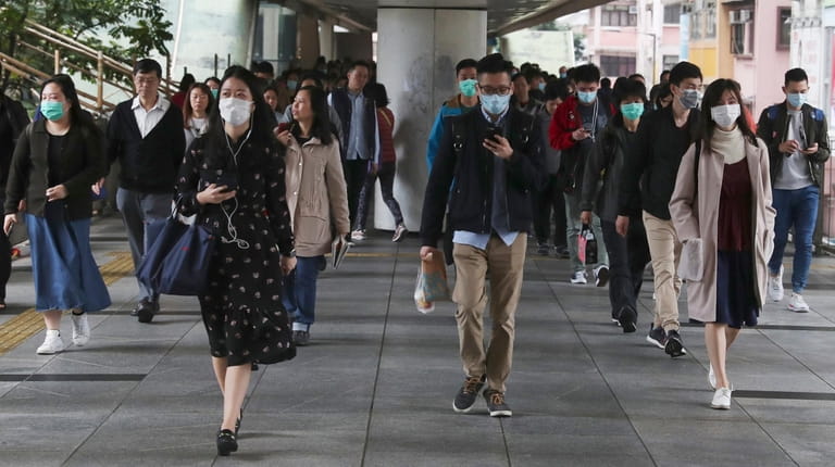 People wear protective face masks on a bridge in Hong...