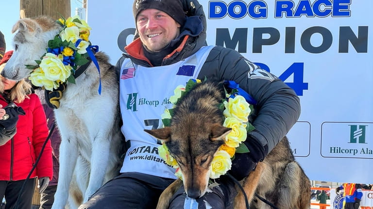 Dallas Seavey sits with his lead dogs Sebastian, left, and...