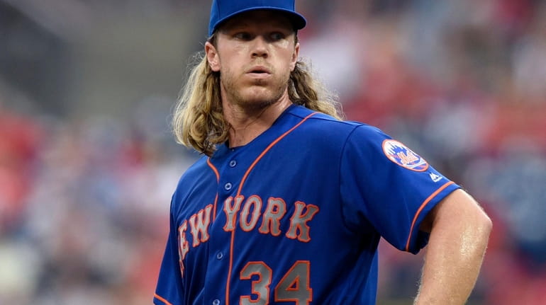 Mets starter Noah Syndergaard reacts after giving up run-scoring double to...