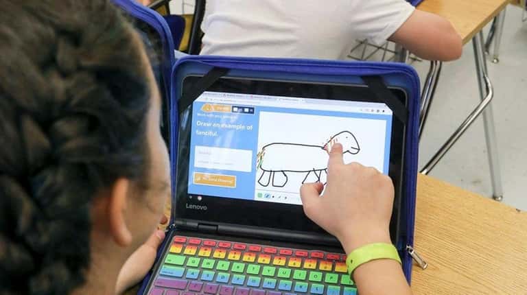 Sixth-graders use school-issued Chromebook computers to work on a vocabulary...