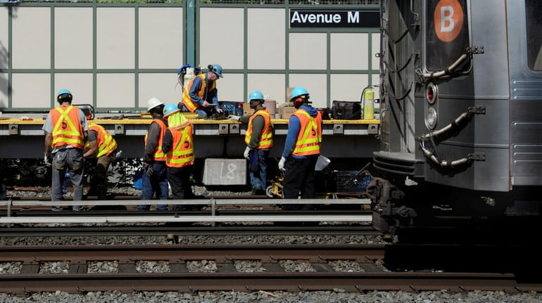 MTA workers create a continuous section welded rail at the Avenue...