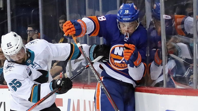 Anthony Beauvillier #18 of the Islanders is checked by Erik...