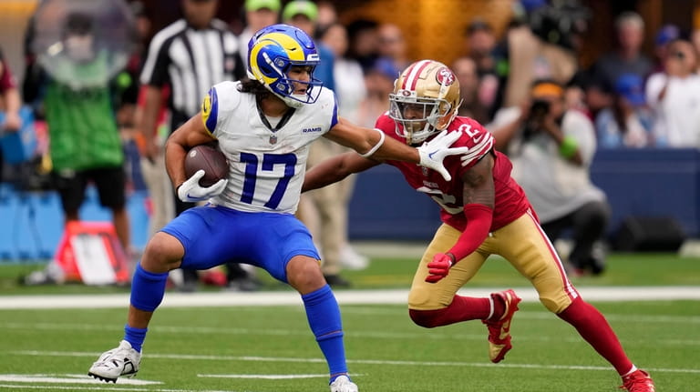 Los Angeles Rams wide receiver Puka Nacua, left, tries to...