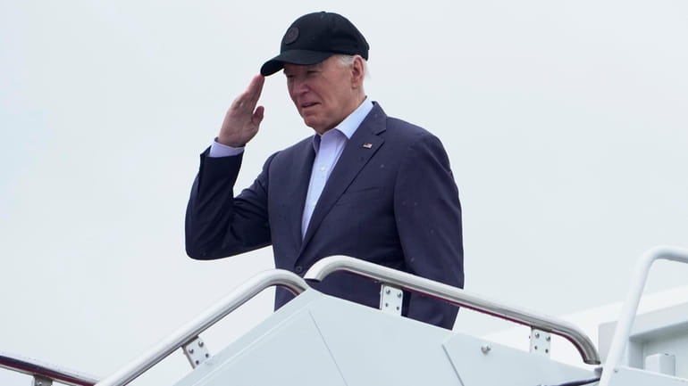 President Joe Biden salutes as he boards Air Force One...