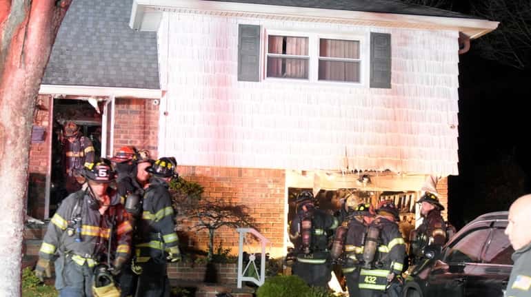 Firefighters at the Martin Street house in Massapequa on Tuesday...