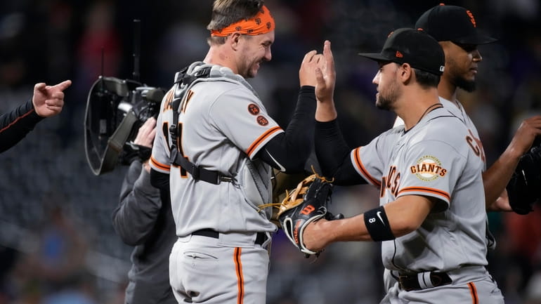 San Francisco Giants catcher Patrick Bailey, left, and right fielder...