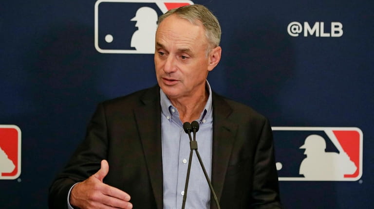 MLB Commissioner Rob Manfred answers questions at a news conference...