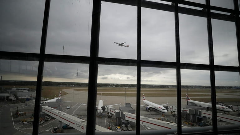 British Airways planes sit parked at Heathrow Airport in London,...