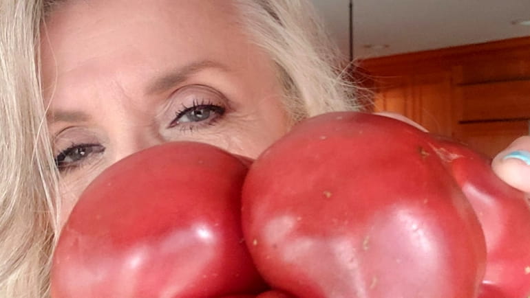 Ellen Meister in her Jericho kitchen with an heirloom tomato...