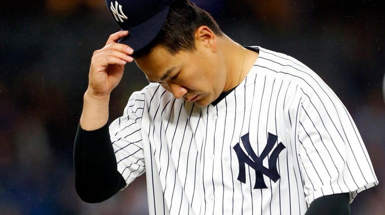 Masahiro Tanaka #19 of the New York Yankees walks to...