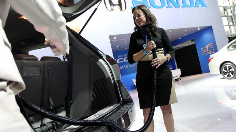 A Honda Motor Co. representative demonstrates the vacuum cleaner that...