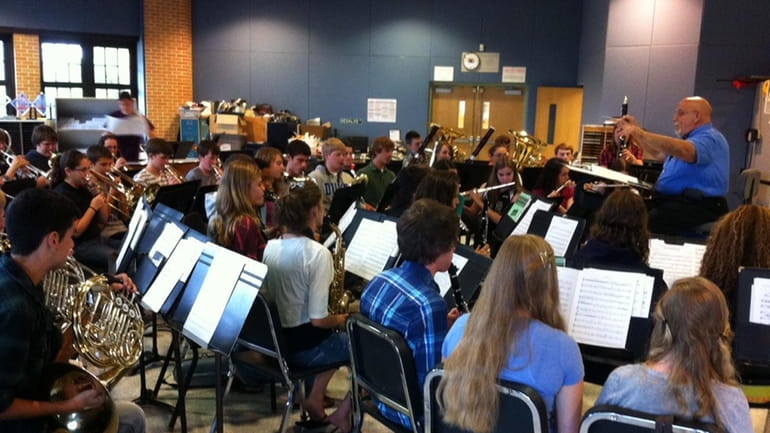 The Sayville High School wind ensemble rehearses songs it is...
