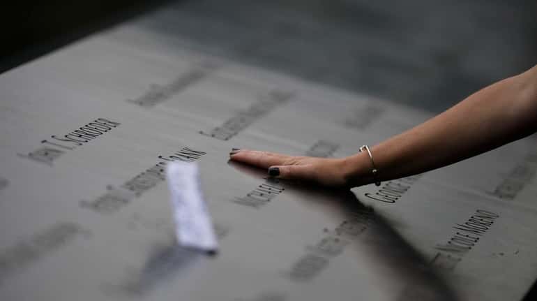 Families gather at the edge of the 9/11 memorial's north...