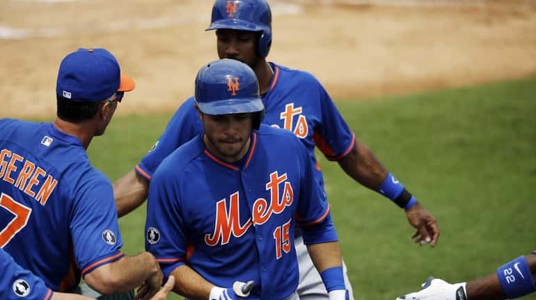 Mets' Travis d'Arnaud, center, is high-fived by teammates after hitting...