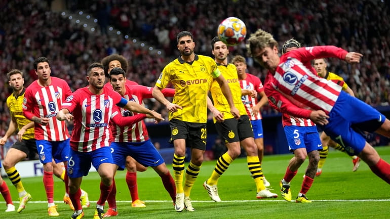 Atletico Madrid's Antoine Griezmann, right, heads the ball during the...