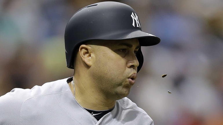 New York Yankees' Carlos Beltran spits sunflower seeds as he...