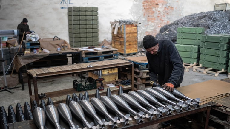 A worker assembles mortar shells at a factory in Ukraine,...
