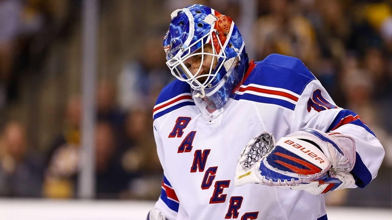 Henrik Lundqvist grimaces in pain from his left arm after...