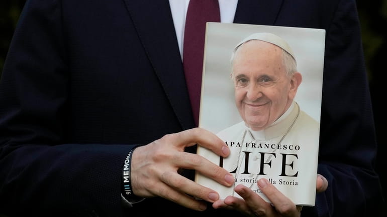 Italian journalist and writer Fabio Marchese Ragona holds a copy...