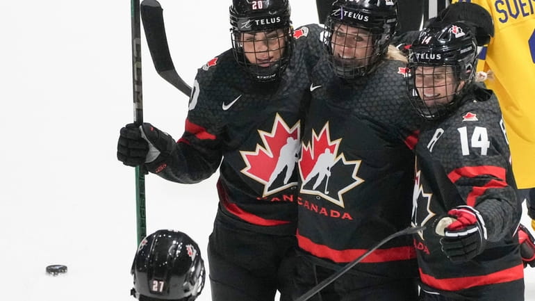 Canada's Natalie Spooner, center rear, celebrates her goal against Sweden...