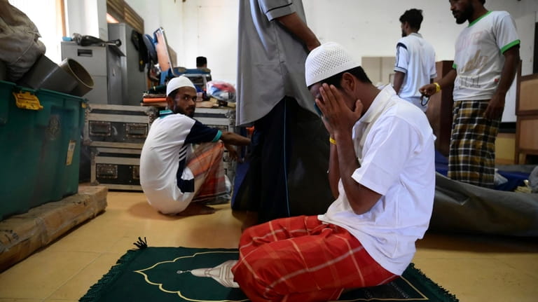 A Rohingya refugee rescued from a capsized boat prays at...