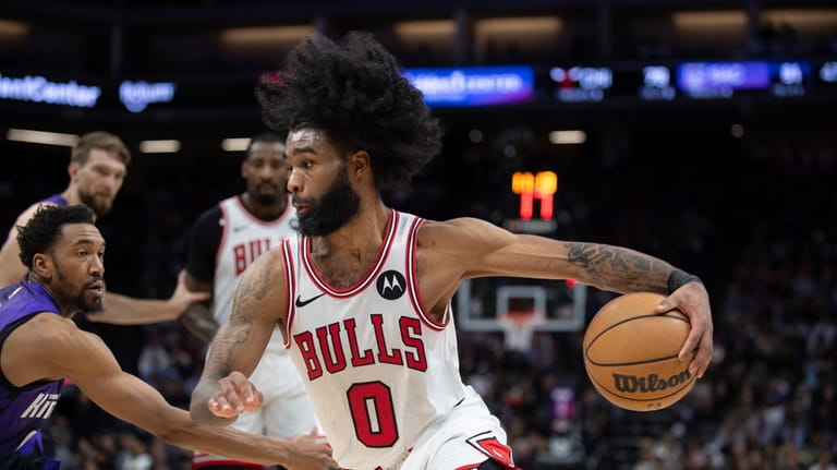 Chicago Bulls guard Coby White (0) drives to the basket...