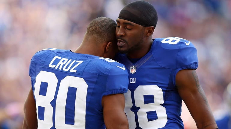 Victor Cruz is congratulated by teammate Hakeem Nicks of the...