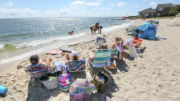 Visitors enjoy a late-summer afternoon at New Suffolk Beach overlooking...