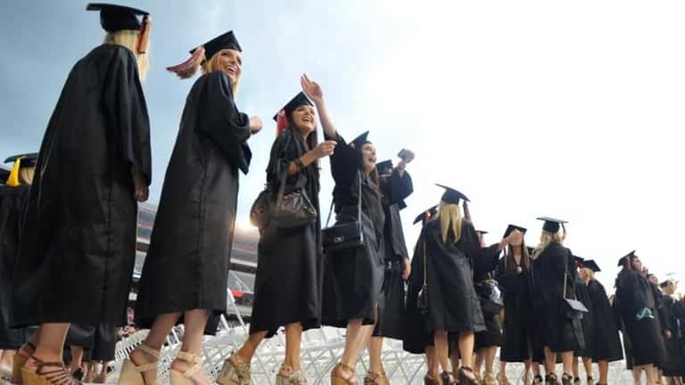 Graduates cheer during the processional portion of the spring commencement...