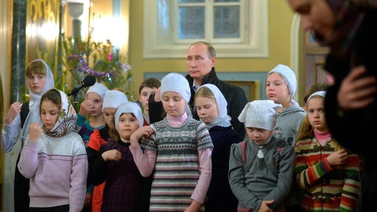 Russian President Vladimir Putin attends a midnight Mass on Russian...