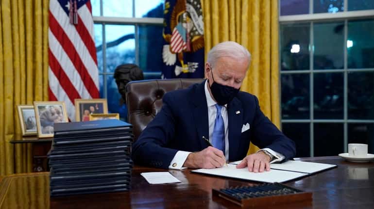 President Joe Biden signs his first executive order Wednesday afternoon...