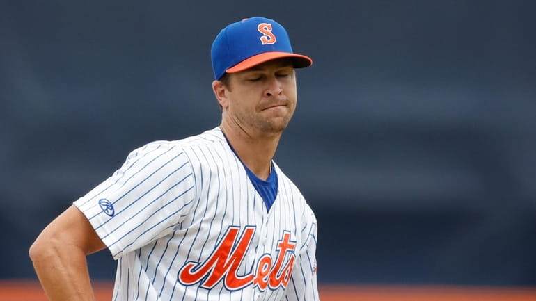 Mets' Jacob deGrom reacts after giving up a home run...