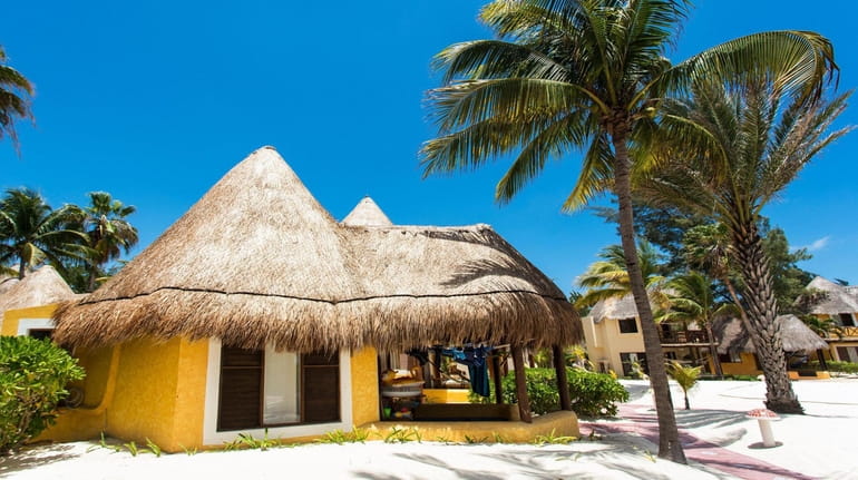 The palapa-style accommodations at Mahekal Beach Resort features thatched roofs in...