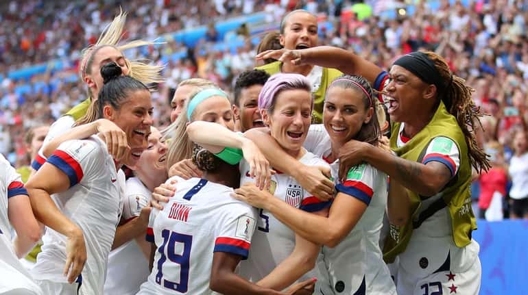 Megan Rapinoe celebrates with teammates after scoring her team's first...