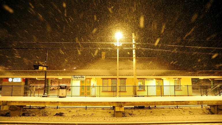 The Sayville train station is covered in snow during a...