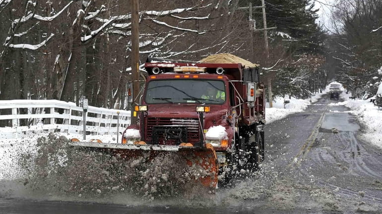 A snow plow clears slush and snow near the Long...