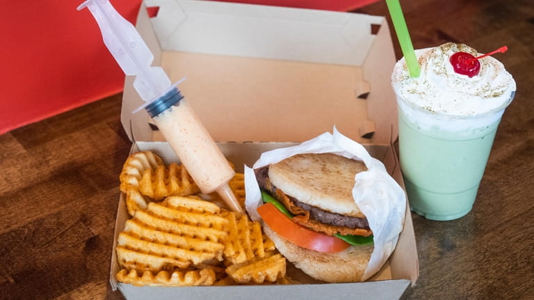 The rice bun burger with waffle fries and a syringe...
