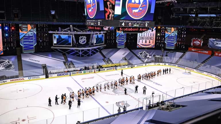 The Islanders and Philadelphia Flyers shake hands following the Islanders' 4-0...