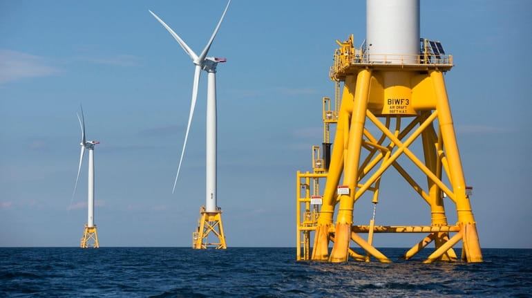Three of Deepwater Wind's turbines stand in the water off...