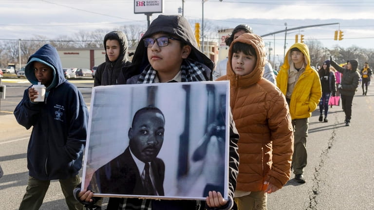 Parade goers march in the Village of Hempstead’s MLK Day...