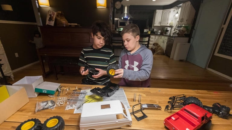 Brothers Shane, 11, left, and Bruce Brocking, 8, work on...